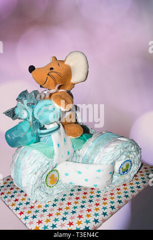 Un gâteau de couche-culotte Tricycle gâteau de couche-culotte avec les rubans bleus. Cadeau pour la naissance d'un enfant Banque D'Images