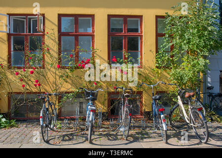 Une ligne de bicyclettes garées devant un bâtiment coloré typiquement à Copenhague. Banque D'Images