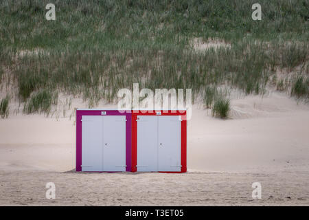 Deux cabines de plage multicolores à Mer du nord plage de Domburg, Zélande, Pays-Bas en face de envahis par les dunes de sable Banque D'Images