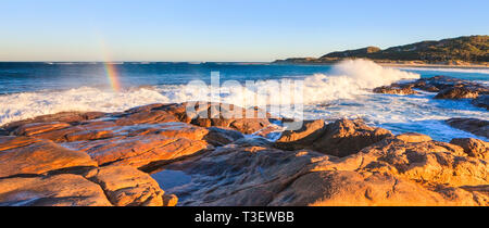 Prevelly Beach, Margaret River. Une vague se brisant sur les rives de Prevelly Beach avec un arc-en-ciel formé par le jet de mer Banque D'Images