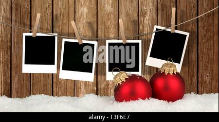 Instant photos vide suspendu à la corde en face de fond de bois avec de la neige et des boules de Noël - Christmas background Banque D'Images