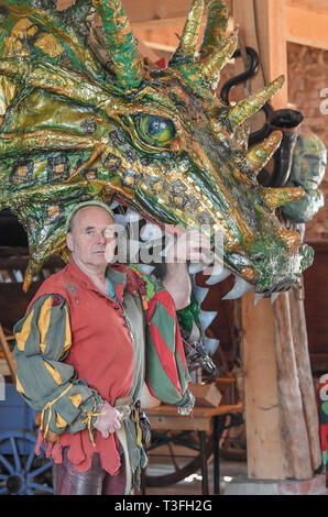 Golzow, Allemagne. Le 08 Avr, 2019. Streisand romain, musicien et artiste, se dresse en face d'un grand dragon figure dans une grange de sa Kulturhof. Le monastère de Pâques Festival en avant du fond de monastère de Chorin est devenu une institution et pour de nombreuses familles une excursion doit les jours fériés. Cette année, il y a la 30e édition. Il a été inventé par Roman Streisand, qui tire toujours les cordes avec son pilwut "bande médiéval'. Crédit : Patrick Pleul/dpa-Zentralbild/ZB/dpa/Alamy Live News Banque D'Images