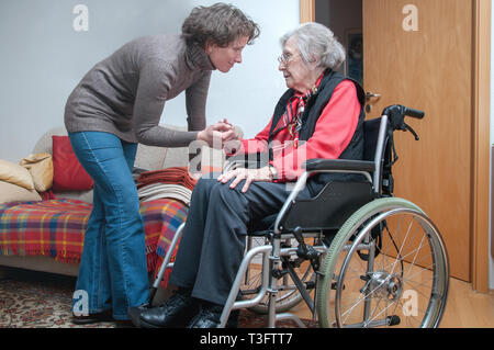 Jeune femme s'occupe d'senior woman sitting in wheelchair Banque D'Images