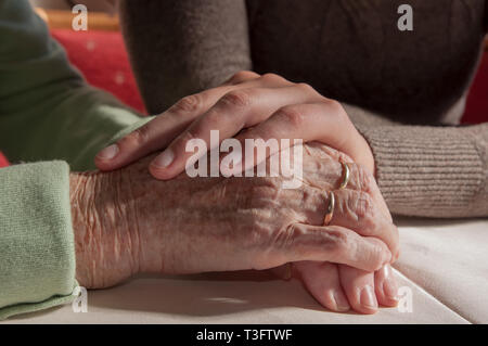 Close up of young woman's hands holding hands of senior woman Banque D'Images