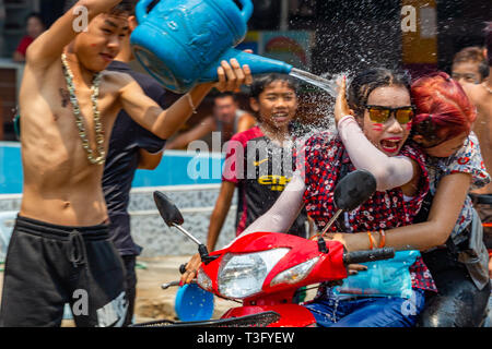 Vang Vieng, Laos - 14 Avril 2018 : Kids jetant de l'eau aux scooters dans la rue et à la célébration du Nouvel An Lao Banque D'Images