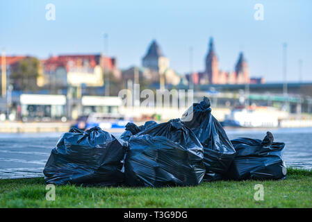 Vos déchets dans des sacs noirs sur fond de la ville. Banque D'Images