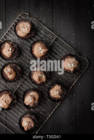 Gâteaux de fées sur un bac de refroidissement avec sprinckled sucre glace sur un fond de bois gris en détresse, en plongée des Banque D'Images