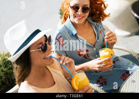 Belles filles s'amusant smiling together in a cafe outdoor Banque D'Images