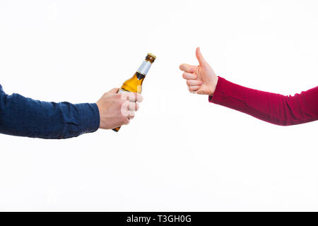 Close up of male hands holding une bouteille de bière et de le proposer à une femme isolée sur fond blanc. L'acceptation du bras humain geste, thumb up Banque D'Images