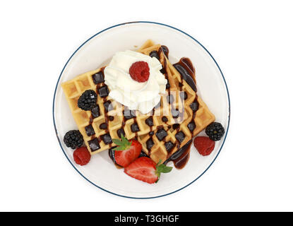 Gaufres Belges garnie de fraises, de fruits et de baies et crème fouettée sur un plateau isolé sur fond blanc Banque D'Images