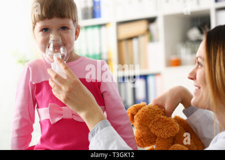 Petite fille avec la respiration à l'inhalateur bureau médecin Banque D'Images