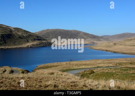 Route étroite winding round Nant y Moch Gamme Plymlimon Réservoir Ceredigion Pays de Galles Cymru UK Banque D'Images