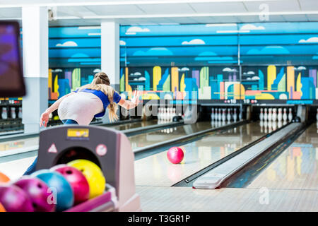 Vue arrière d'une jeune femme bowling Banque D'Images