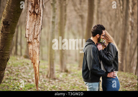 Histoire d'amour de cool couple multiracial en forêt au printemps. Banque D'Images