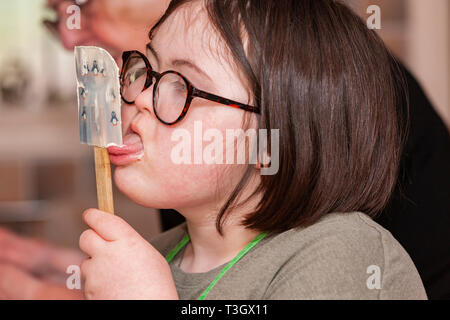 Jeune fille avec le syndrome de Down à la vie quotidienne d'apprentissage avec sa grand-mère dans la cuisine. Banque D'Images