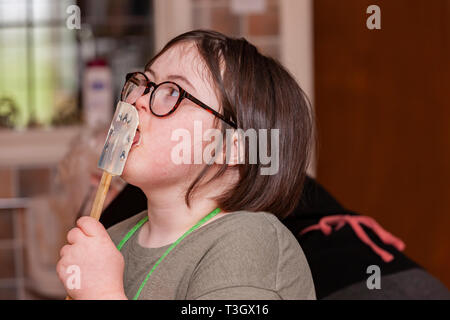 Jeune fille avec le syndrome de Down à la vie quotidienne d'apprentissage avec sa grand-mère dans la cuisine. Banque D'Images