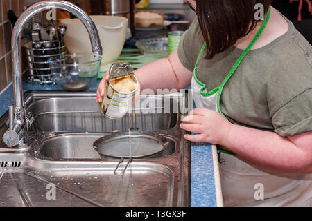 Jeune fille avec le syndrome de Down à la vie quotidienne d'apprentissage avec sa grand-mère dans la cuisine. Banque D'Images