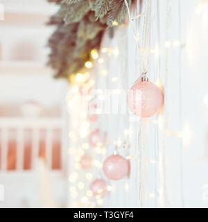 Décoration de Noël et Nouvel An. Selective focus on clair rose boules scintillantes guirlandes ang accroché sur la composition de la paroi. Arrière-plan de vacances de Noël Banque D'Images