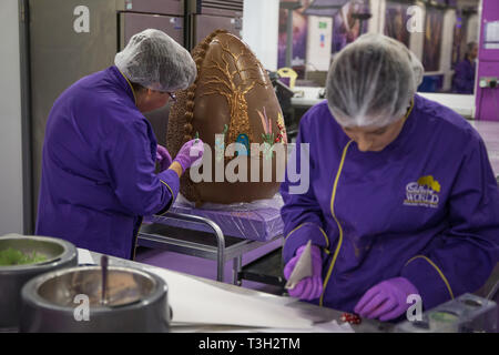 Chocolatiers décorer un oeuf en chocolat géant à Cadbury World à Birmingham pour célébrer Pâques. Banque D'Images