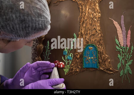 Chocolatiers décorer un oeuf en chocolat géant à Cadbury World à Birmingham pour célébrer Pâques. Banque D'Images