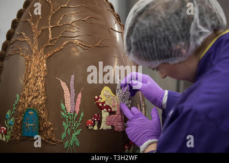 Chocolatiers décorer un oeuf en chocolat géant à Cadbury World à Birmingham pour célébrer Pâques. Banque D'Images