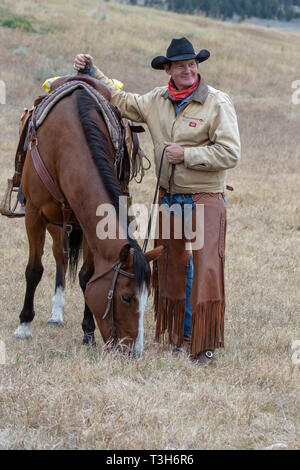 Smiling American cowboy se trouve à côté de cheval dans le Wyoming Banque D'Images