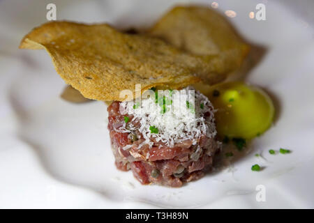 Steak tartare servi avec une fine tranche de pain croustillant. La viande crue est complété avec du fromage râpé. Banque D'Images