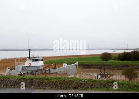 Bateau de pêche amarré le long de la rivière Humber dans le Nord du Lincolnshire. Le Humber Bridge peut être vu dans la distance. Banque D'Images