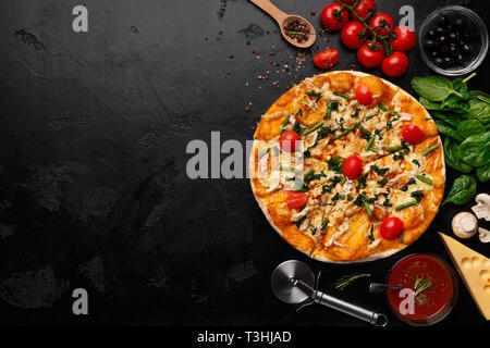 Pizza avec salade de roquette et tomates cerises Banque D'Images