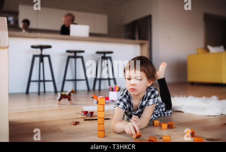 Une petite fille jouant sur le plancher à la maison. Banque D'Images