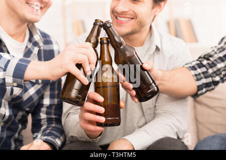 Cheers. Les amis de trinquer les bouteilles de bière à la maison Banque D'Images