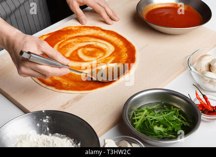 Processus de préparation de pizza. Diffusion Chef de la sauce tomate Banque D'Images