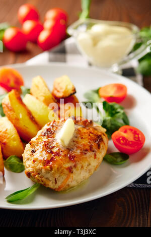 Escalope de poulet frit avec des tranches de pommes de terre servies avec de la tomate cerise et salade de maïs. Le réseau traditionnel - l'alimentation la viande hachée et de pommes de terre rôties Banque D'Images