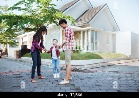 Mère et père d'Asie avec kid jouer autour de leur maison Banque D'Images