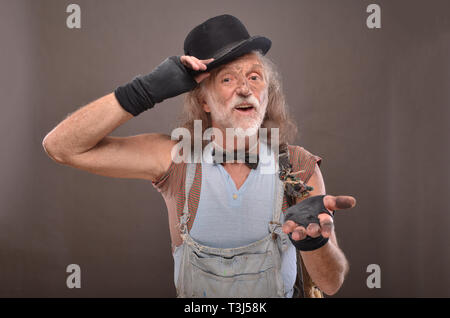 Vieux et sale sans-abri mendiant de toucher son chapeau noir et demander de l'argent, studio shot Banque D'Images