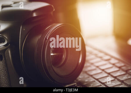 Appareil photo numérique gros plan reflex numérique avec objectif fixe normal de l'ordinateur sur le clavier d'ordinateur portable. Banque D'Images