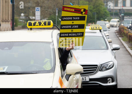 Stuttgart, Allemagne. 10 avr, 2019. Les chauffeurs de taxi avec une bannière de protestation contre les plans de ministre fédéral des Transports Scheuer. Avec des démonstrations à l'échelle du pays, les chauffeurs de taxi veulent s'opposer à la libéralisation du marché. La location de voiture et Taxi Allemand Association (BZP) a appelé les conducteurs dans environ 30 villes allemandes pour protester. Credit : Oliver Willikonsky/dpa/Alamy Live News Banque D'Images