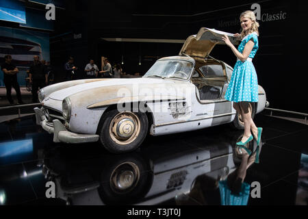 Essen, Allemagne. 10 avr, 2019. Au Techno Classica, modèle Alida se place en avant d'une Mercedes-Benz 300 SL Gullwing à partir de 1954. La foire a lieu du 10 au 14 avril. Crédit : Marcel Kusch/dpa/Alamy Live News Banque D'Images