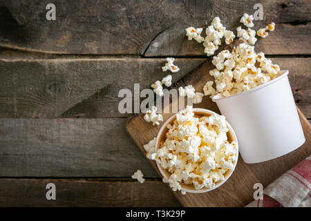 Pop corn fait maison en bois blanc sur fond tasses Banque D'Images