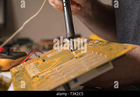 Électronique technicien en soudage et la réparation de la puce d'ordinateur Banque D'Images