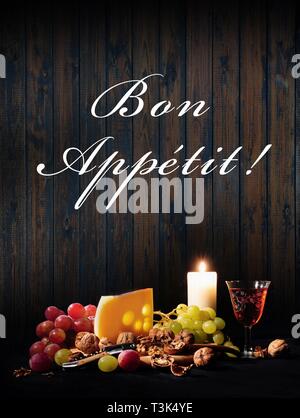 Nature morte avec du vin, du fromage, des raisins, bougie, Bon Appétit ! Banque D'Images