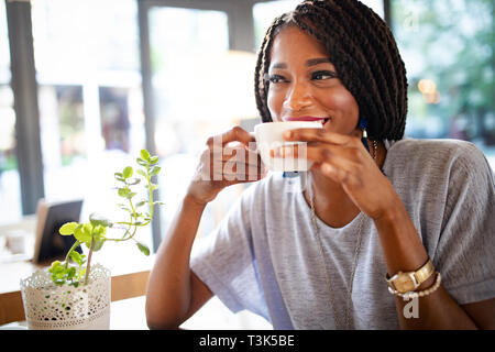 Belle jeune femme africaine savourer une tasse de café Banque D'Images