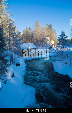 Vieux moulin désaffecté assis sur les rives d'une rivière qui coule, Finlande, d'Oulanka, Mars 2018 Banque D'Images