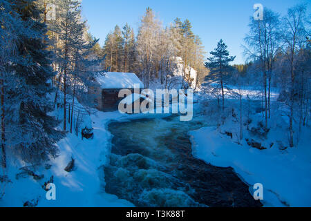 Vieux moulin désaffecté assis sur les rives d'une rivière qui coule, Finlande, d'Oulanka, Mars 2018 Banque D'Images