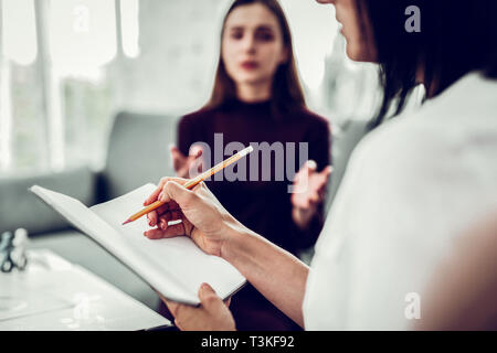 Psychologue de la famille des notes dans le processus de l'écoute Banque D'Images