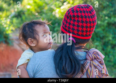 Chiang Mai, Thaïlande - Nov 2015 : mère avec red hat portant son bébé dans les bras Banque D'Images