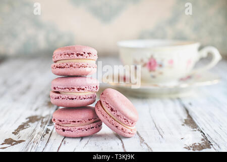 Pile de macarons fraises rose français frais sur une table rustique blanc.. Banque D'Images
