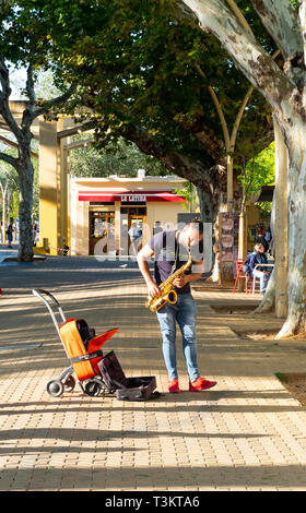 Busker jouant le sax alto et tapotant son pied à Alameda de Hercules à Séville Banque D'Images