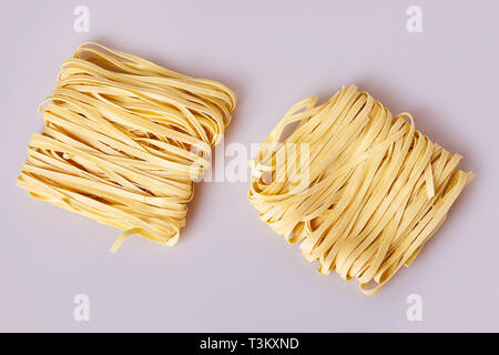 Nouilles laminées sèches d'épaisseur de forme carrée. Capelli d'angelo, les cheveux d'Ange - pâtes. Les pâtes italiennes tagliatelles faites maison. La cuisine italienne. Les nouilles aux oeufs. Banque D'Images