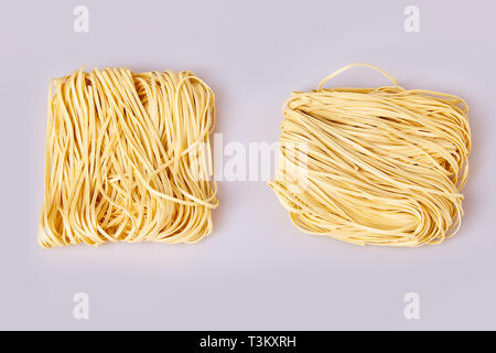 Nouilles laminées sèches d'épaisseur de forme carrée. Capelli d'angelo, les cheveux d'Ange - pâtes. Les pâtes italiennes tagliatelles faites maison. La cuisine italienne. Les nouilles aux oeufs. Banque D'Images